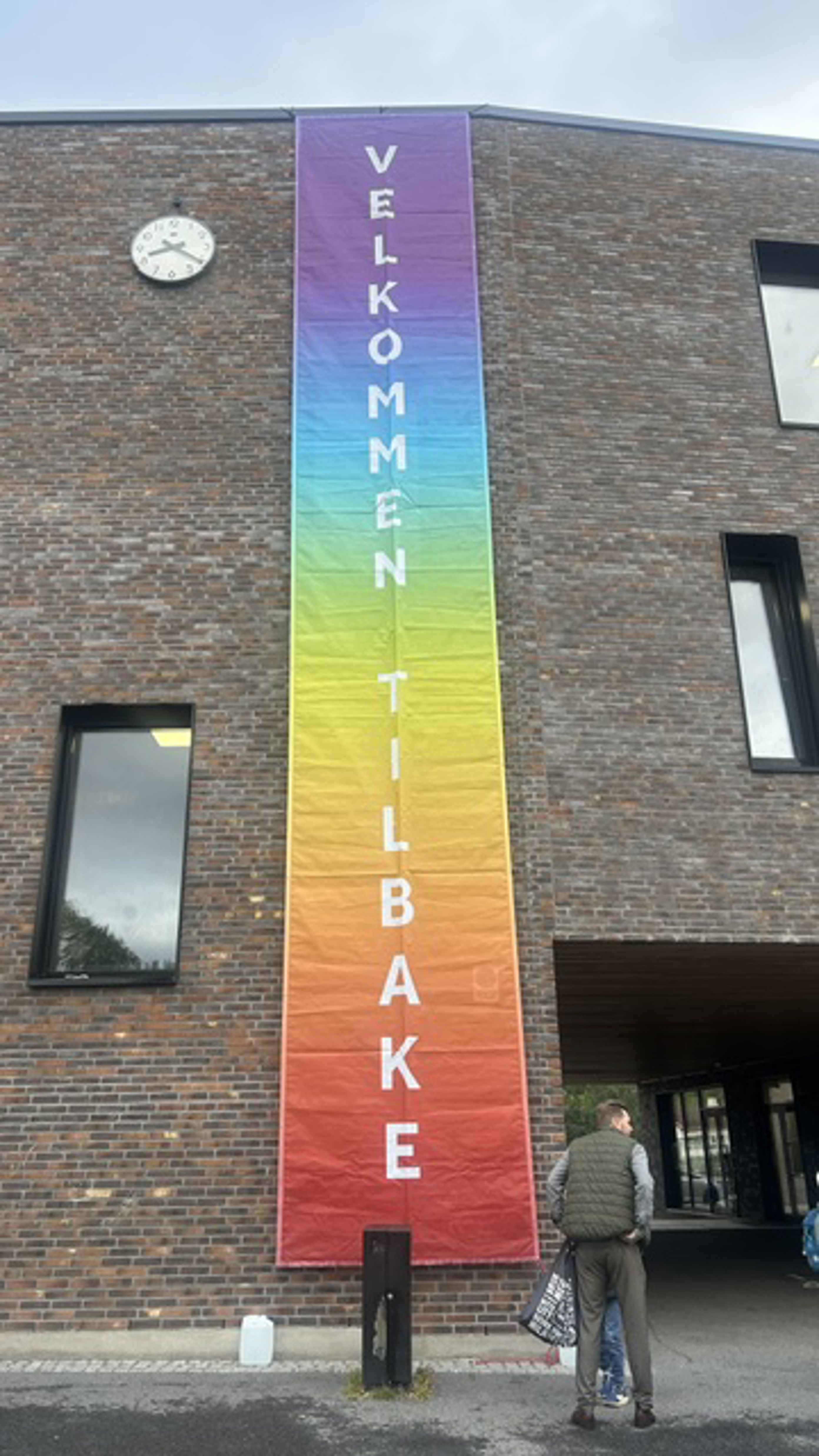 en person som står ved siden av et høyt skilt