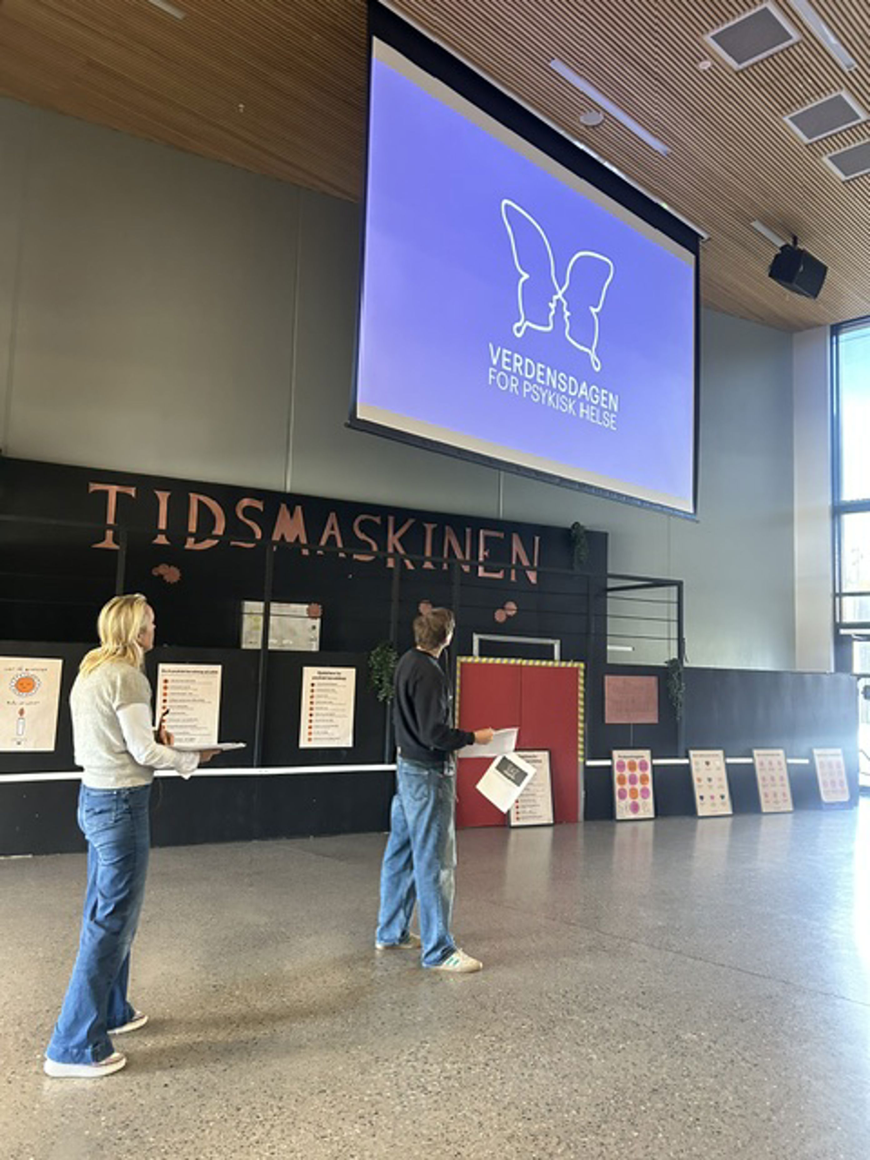 en person og en person som ser på en stor skjerm en person og en person som ser på en stor skjerm