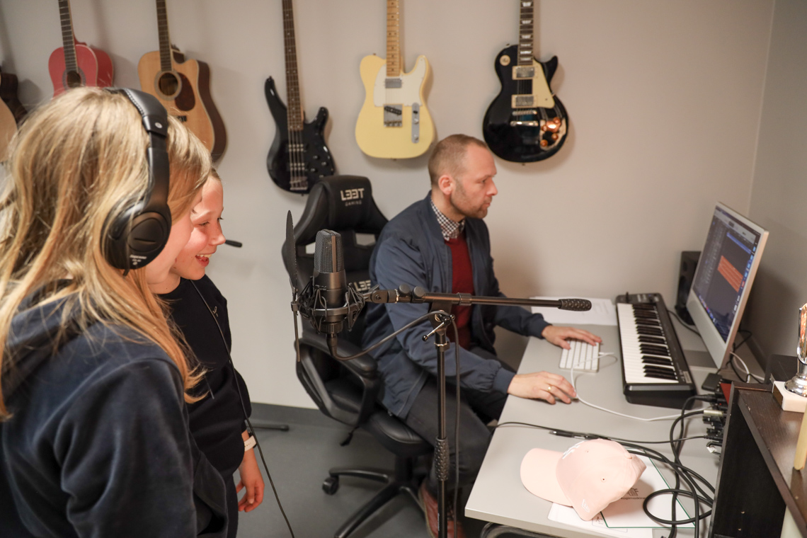 Jenter med lærer i musikkrom.