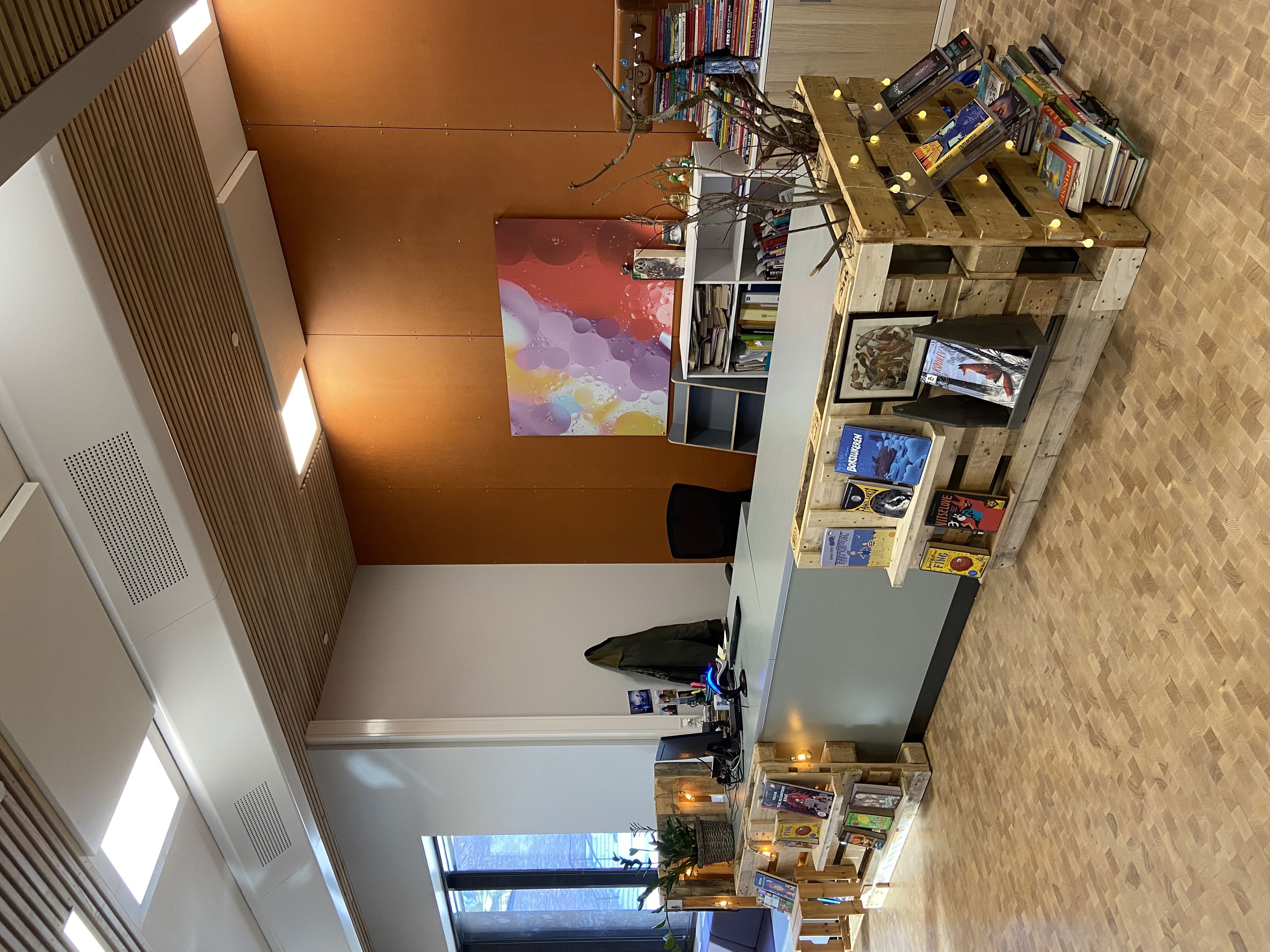 et rom med disk og hyller med bøker på et rom med disk og hyller med bøker på